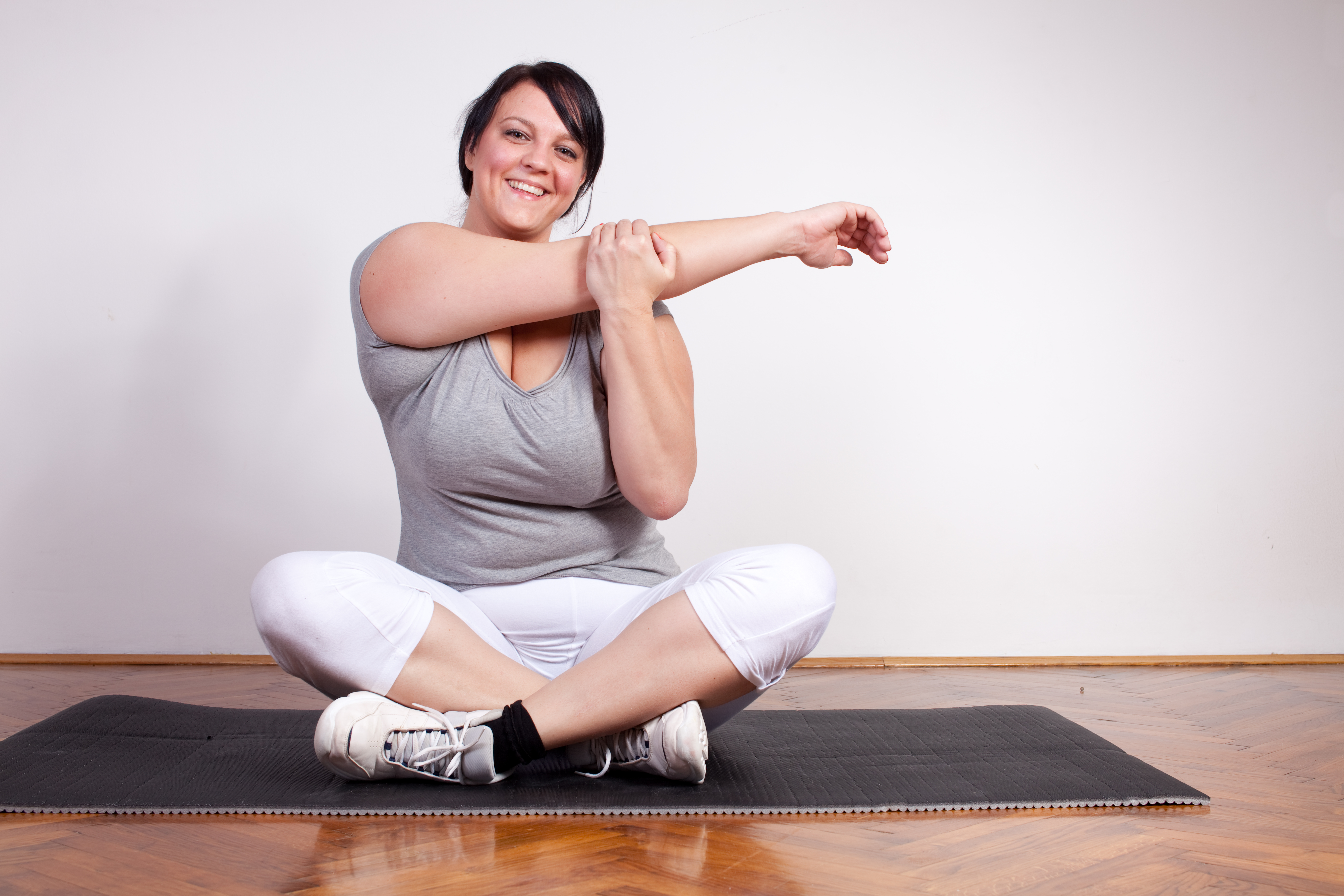 Woman stretching on a mat indoors