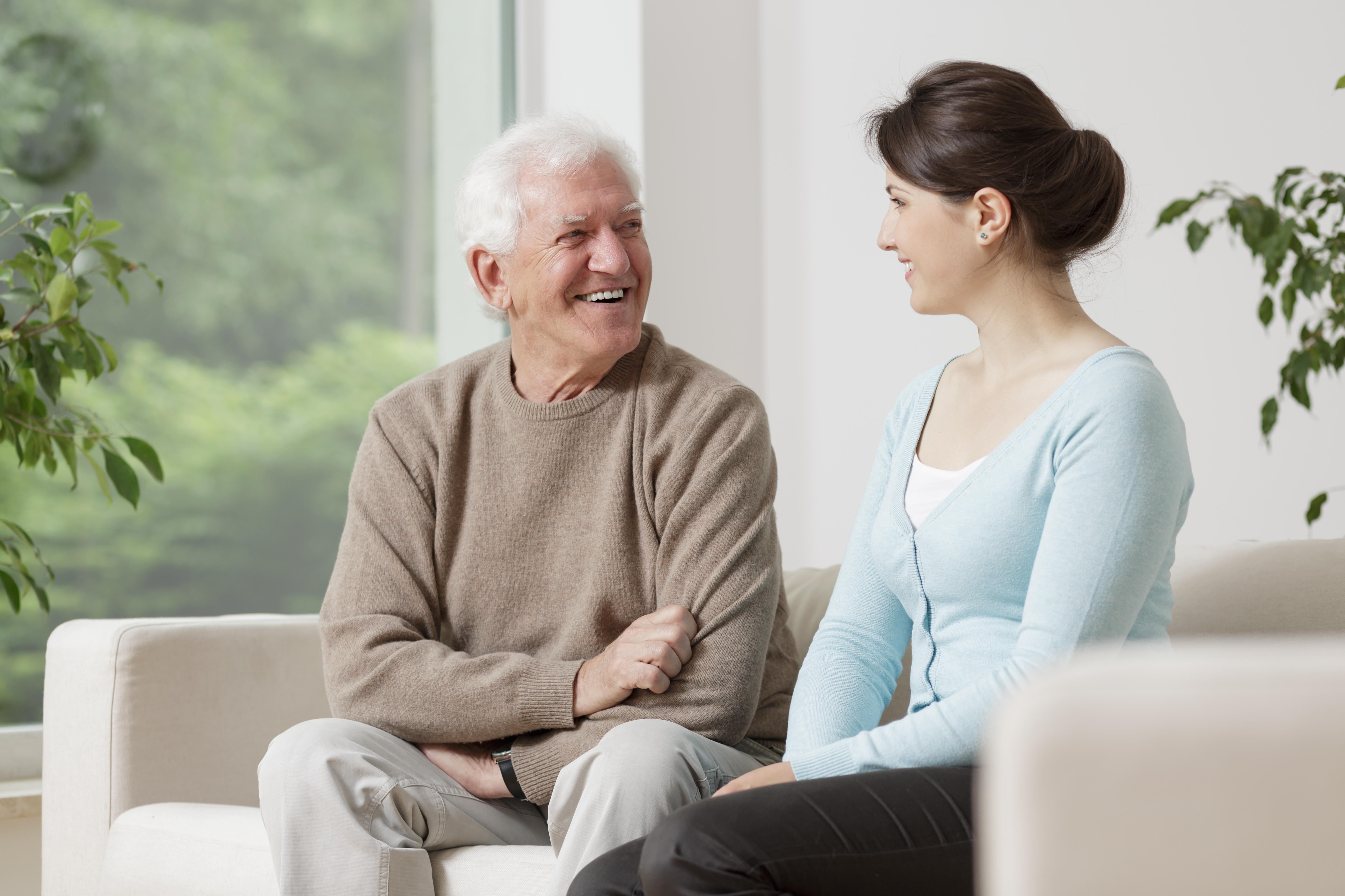 Man speaking to woman on couch
