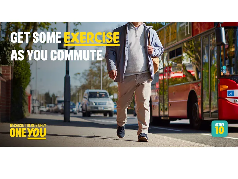 Man walking past a bus - get some exercise as you commute