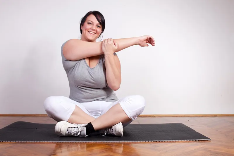 Woman stretching on a mat indoors