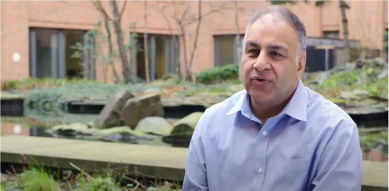 Adrish talking to camera in a garden courtyard