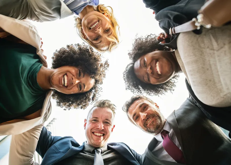 A group of smiling people looking down at the camera
