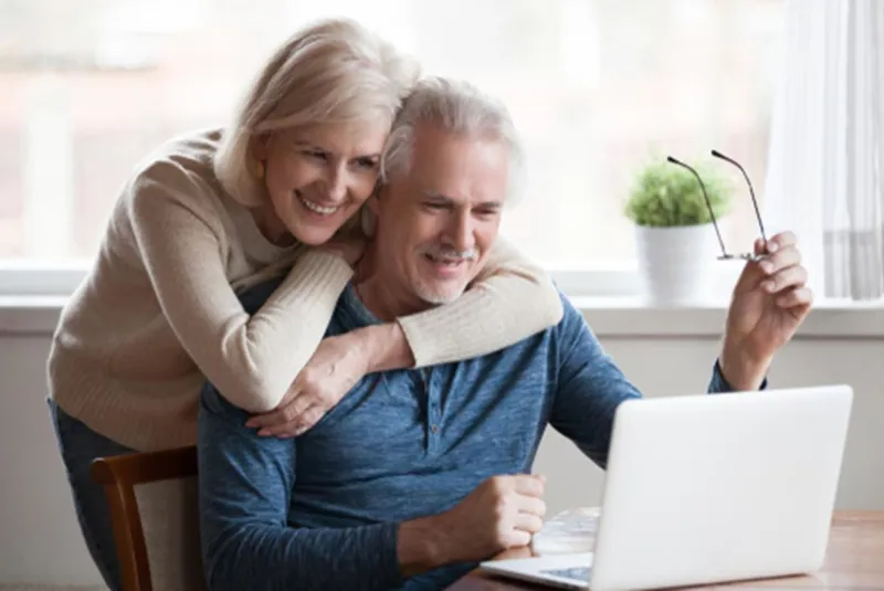 Couple looking at a laptop together at home