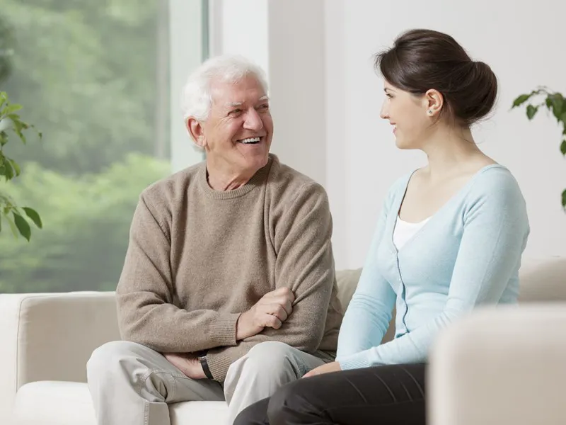 Man talking to a woman on a sofa