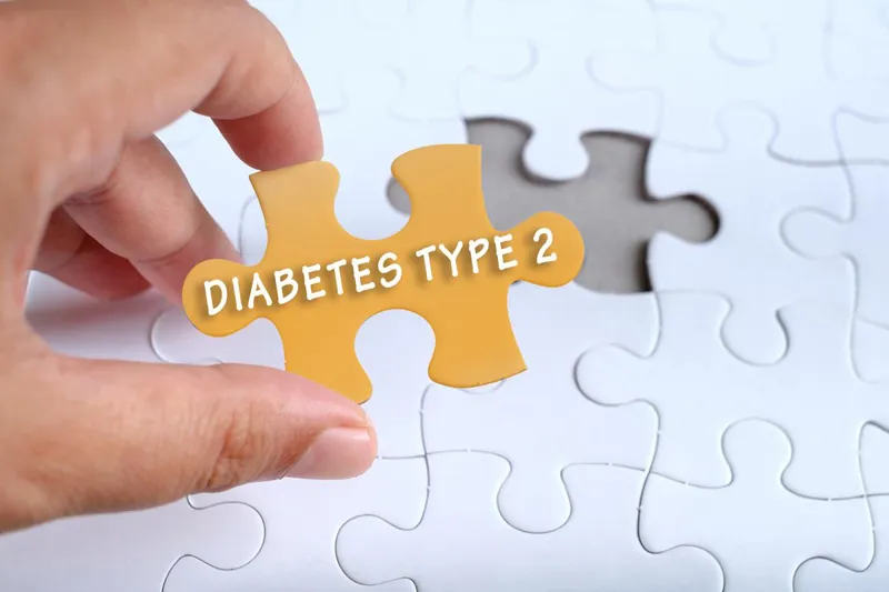Hand fitting a jigsaw piece labelled Diabetes Type 2 into a puzzle