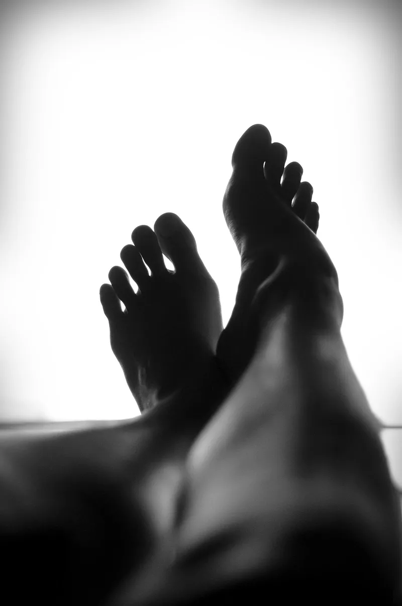 Bare feet resting, in black and white