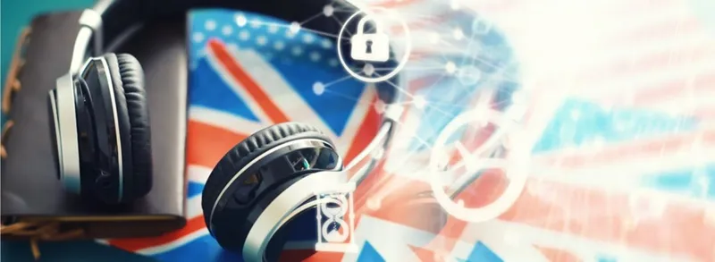 Headphones resting on a book with a Union flag behind