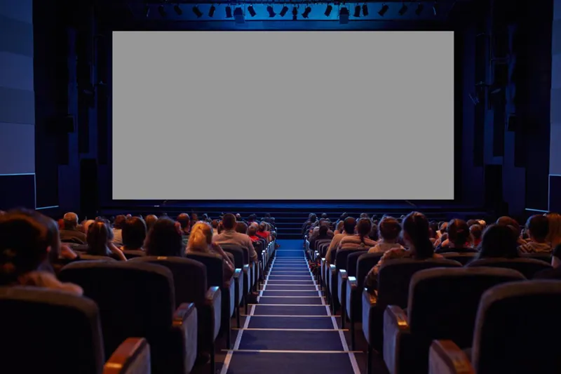 Audience seated in front of a blank cinema screen