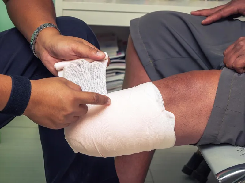 Nurse bandaging a patient's lower leg