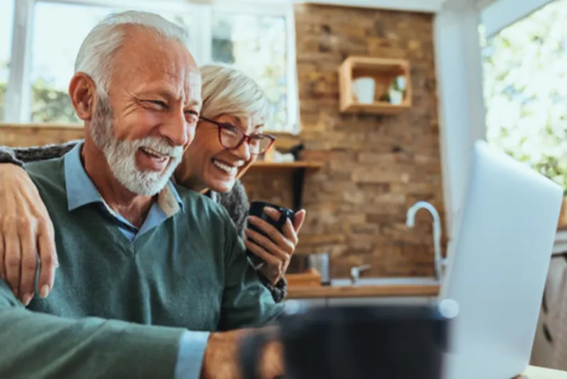 Couple smiling at a laptop screen