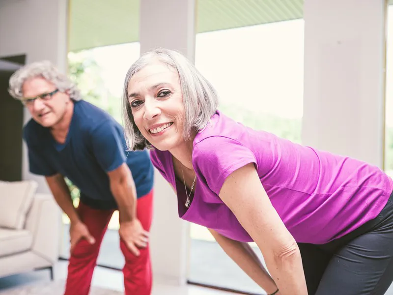 Two people stretching indoors
