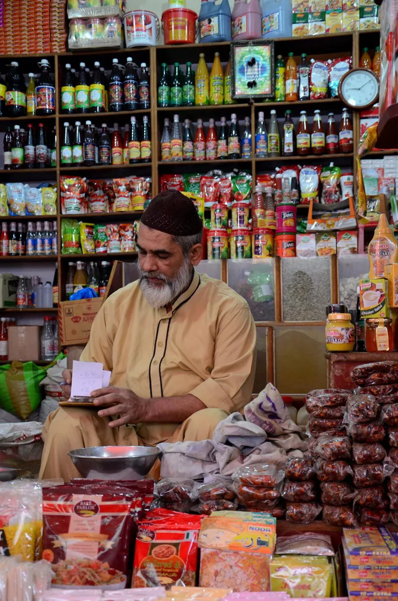 A shop owner in his general provision store at the historical Empress Market in Karachi, Pakistan