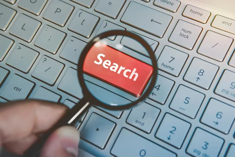 Magnifying glass over a red Search key on a keyboard