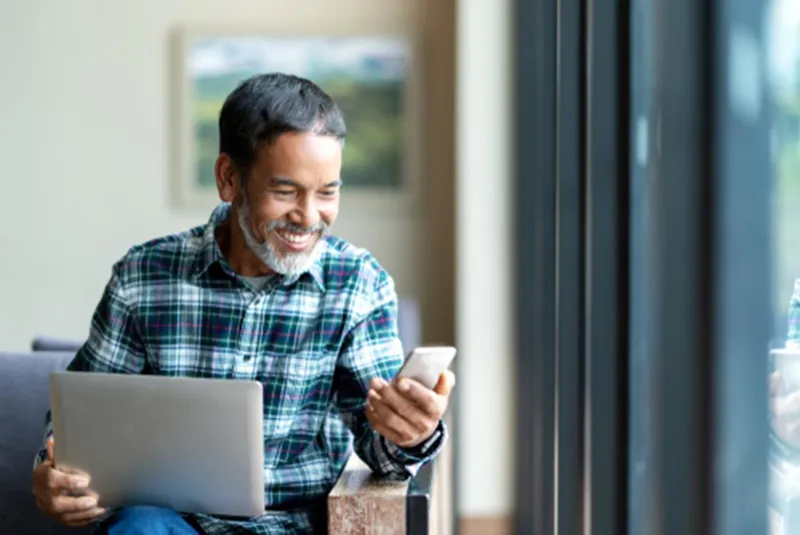 Man holding a phone and a document