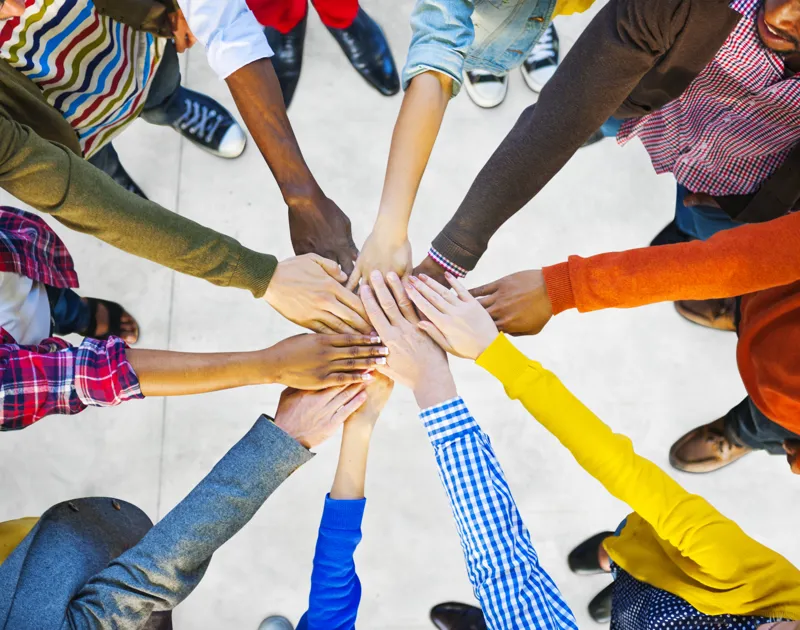 A group of people putting their hands together