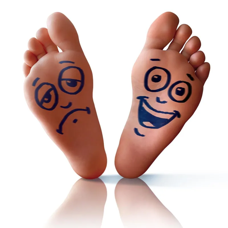 Two feet with cartoon faces drawn on the soles