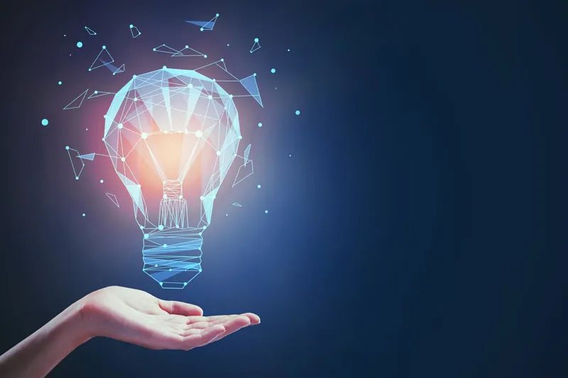 Glowing lightbulb hovering above an open hand