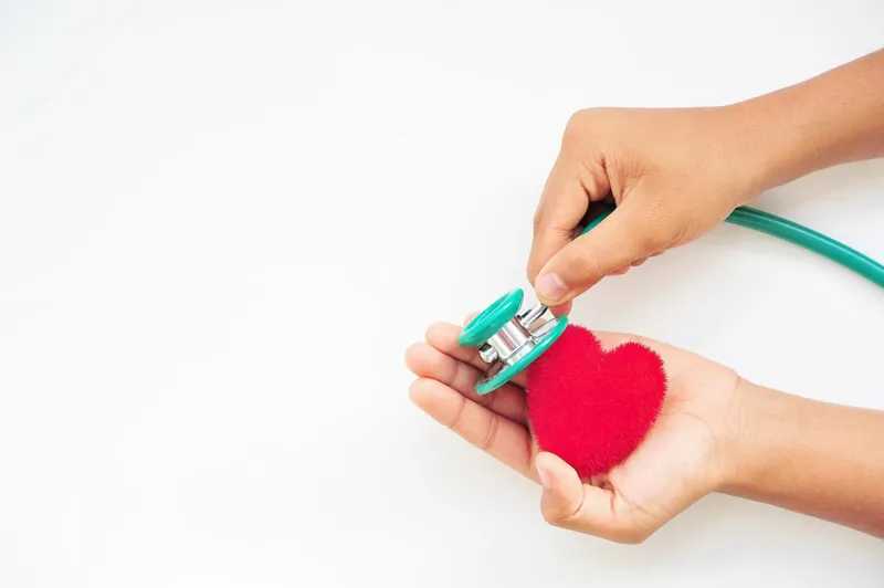 Stethoscope held against a fabric heart