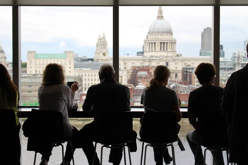 People sitting at a window looking out at St Paul's Cathedral
