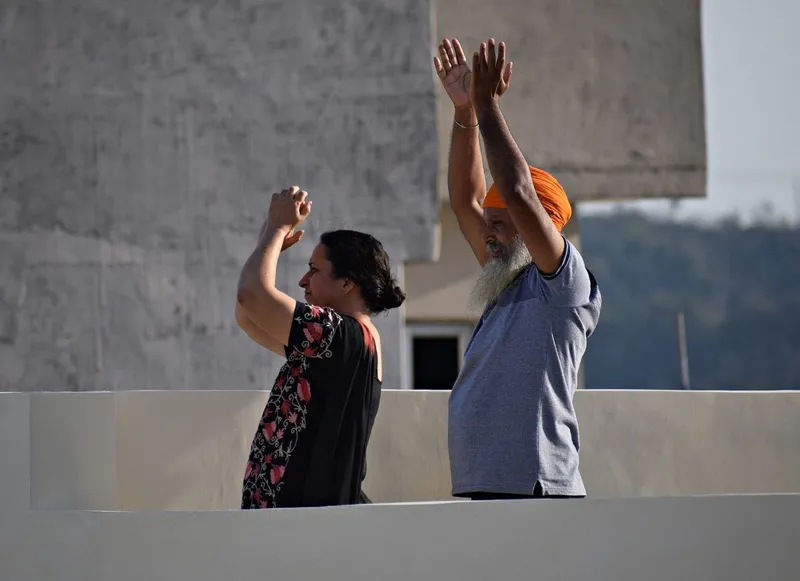 Two people stretching their arms above their heads outdoors